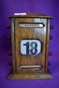 A vintage oak cased perpetual desk top calendar.