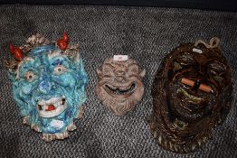 A collection of three ceramic masks.
