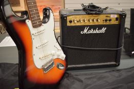 An Encore electric guitar (Fender Stratocaster style) and a Marshall MG15CD practice amplifier