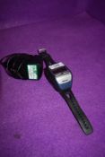 A modern sports running watch by Garmin the Forerunner 205 with charger and cradle.