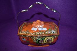 A Royal Winton orange lustre biscuit barrel with handle having floral design with gilt edging.