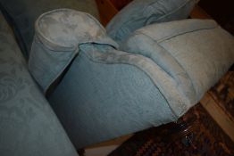 A traditional low seat armchair of deep proportions on mahogany bun feet