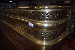 A traditional brass pierced fire fender, width approx. 122cm
