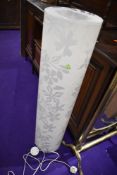 A modern floor standing lamp of moulded plastic form in opaque floral design