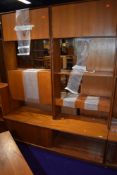 A vintage teak G plan shelf unit having cupboard and cocktail sections with sliding door base, width