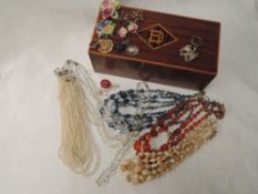 A treen jewellery box having monogram HD to lid, containing a small selection of costume jewellery