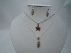 An Edwardian silver pendant in the form of an embossed star having a central red paste gem on a