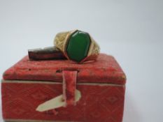 A Far Eastern yellow metal signet ring stamped 18 having plain octagonal jade panel, bearing Chinese