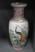 A large standing Cantonese styled floor vase having peacock enamel scene and standing at 60cm tall