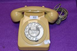 A mid century GPO telephone set or reciever in a cream yellow colour