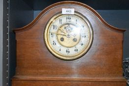 An antique mahogany cased mantle clock with a brass and enamel faced dial