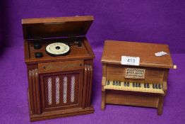 Two miniature model music boxes one styled as a piano and similar jukebox