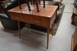 A vintage teak side table, previously housing a sewing machine, on dansette style legs