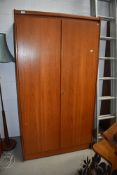 A vintage teak wardrobe having partially fitted interior