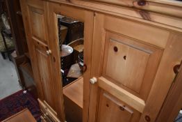 A natural pine mirror door wardrobe, having drawer base, width approx. 150cm