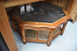 A modern glass top coffee table of octagonal form, shaped top and canework undertier, width
