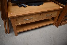 A modern golden oak coffee table/TV stand with drawers and undershelf