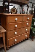 A stripped pine chest of two over three drawers
