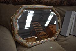 A bevel edged mirror having floral work frame