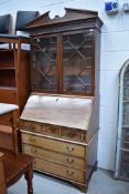 A late 19th or early 20th mahogany bureau bookcase, locked stamped VR, glazed upper section being