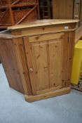 A modern natural pine corner cupboard