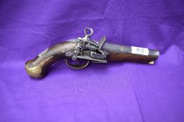 An early belt flintlock pistol, engraved brass mounts, decorated barrel and stock, lock highly