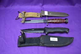 A Made in China Fighting Knife with rubberized grip and canvas scabbard, overall length 28cm along