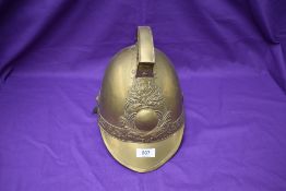 A vintage French brass Firemans Helmet, Pompiers De Amponville, with leather chin strap and lining