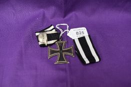 A German 1813-1914 Iron Cross with ribbon and white metal badge Der Stahlhelm along with a spare