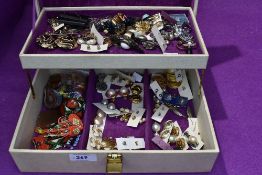 A jewellery box containing a selection of earrings etc
