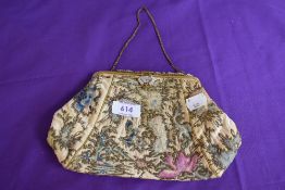 An antique framed evening bag having clasp fastening with beading,and floral pattern of colourful