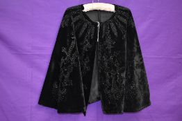 A Victorian cape in black velvet having extensive jet or similar beading throughout.