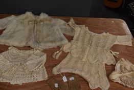 A collection of baby and childrens clothing including fur coat and bonnets, mostly around 1920s.