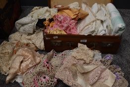 A vintage suitcase containing a large selection of table linen,crotchet work and more.