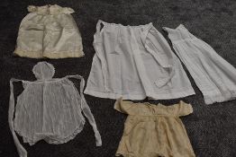 A collection of baby clothing including gowns and apron, all around 1920s.