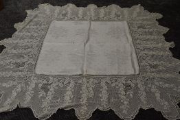 A antique damask table cloth having an indulgently deep and intricate scalloped crotchet edge.