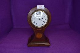 An Edwardian mahogany mantel clock having inlaid detail to waisted front and roman numerals to