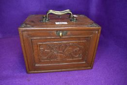 A vintage miniature oak chest of drawers containing a selection of games having inlaid and carved