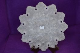 An intricately carved semi opaque plate,mineral or similar, having grape vine detail.