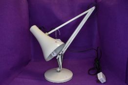 A white anglepoise desk light.