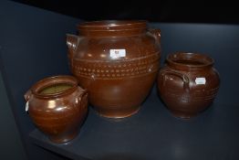 Three vintage stoneware urns/planters of varying size.