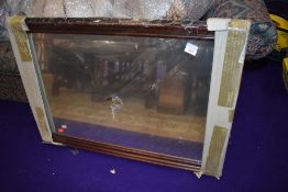 A reproduction mahogany wall mirror, still in packaging