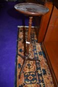 A late 19th/early 20th Century mahogany wine table on turned column and triple splay legs,