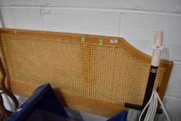 A modern oak effect and canework headboard