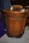 A reproduction mahogany effect corner cupboard base
