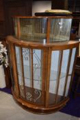 A mid 20th Century walnut demi lune display cabinet