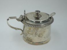 A Victorian silver mustard pot of plain cylindrical form having gadrooned rim and scallop shell