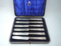 A cased set of six Edwardian silver handled dessert knives having moulded handles with scallop shell