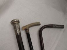 Two vintage walking sticks and a bent cane stick, all having HM silver knops or collars