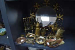 A vintage brass wall mirror having scrolls and flowers to edge and an assortment of other brass